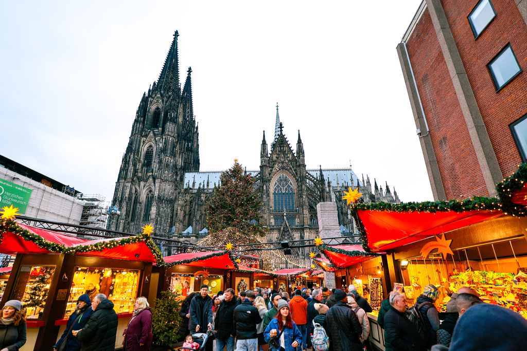 A festive Christmas Market in Cologne, Germany with the cathedral in the background