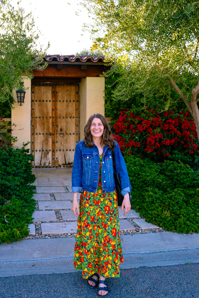 A woman in Toad & Co dress standing in front of a home in the movie colony