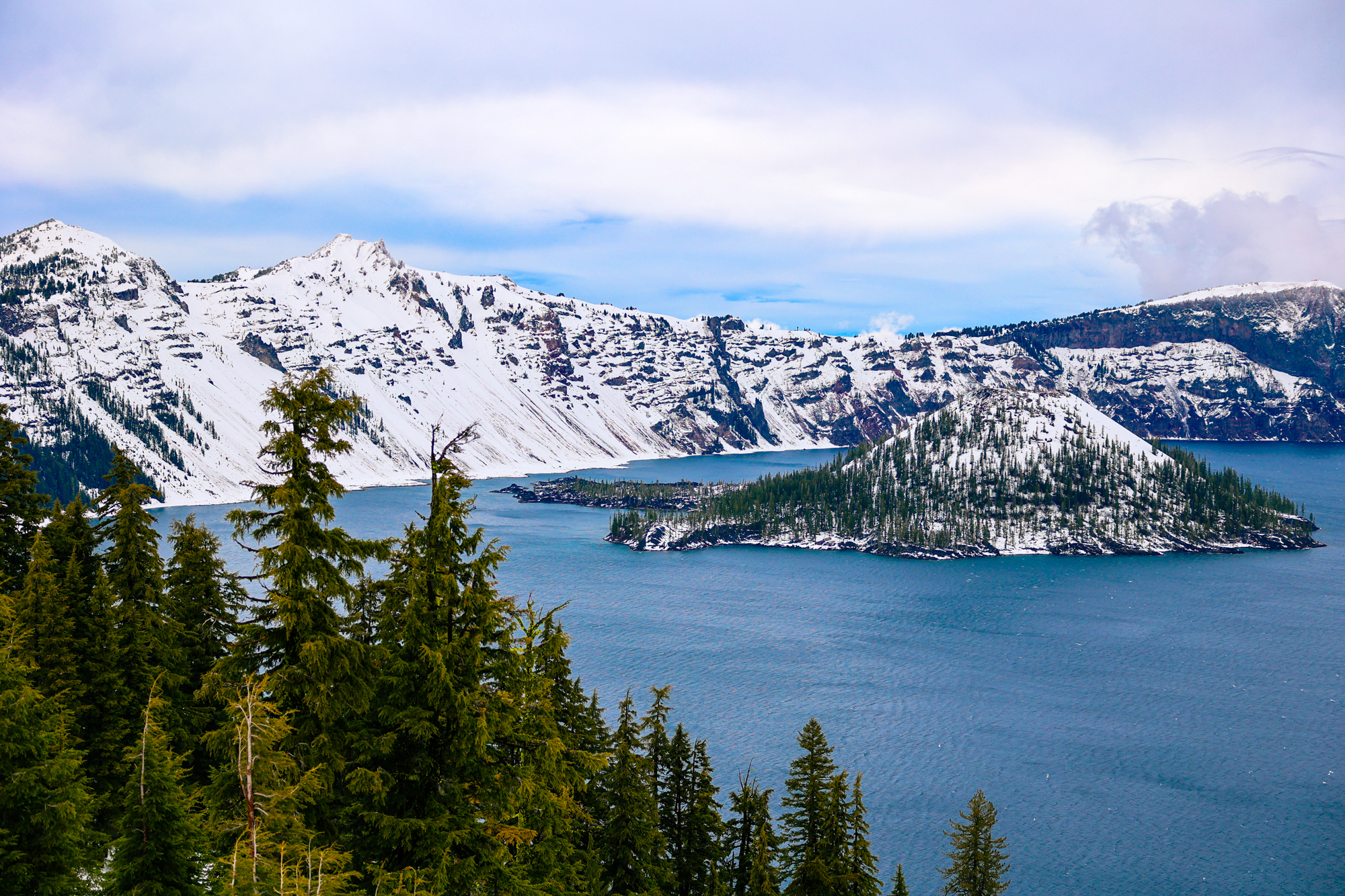 Visiting crater lake national park in winter. A picture of crater lake and wizard island in the snow.
