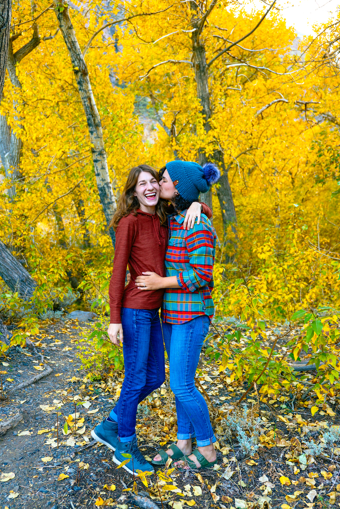 Gwyn and Ami amongst the fall leaves in Mammoth, California in fall. Gwyn and Ami are an LGBTQ+ couple that creates travel, hiking, and outdoor adventure content.