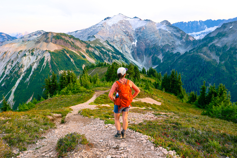 Woman standing on the hannegan pass and peak trail at the final ascent up to hannegan peak inw washington with views of moiuntains in summer