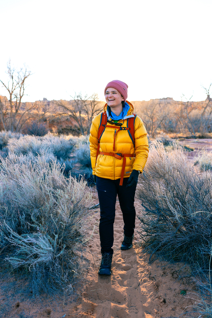 Woman wearing a Stio Hometown Jacket for a winter hike in Arches National Park