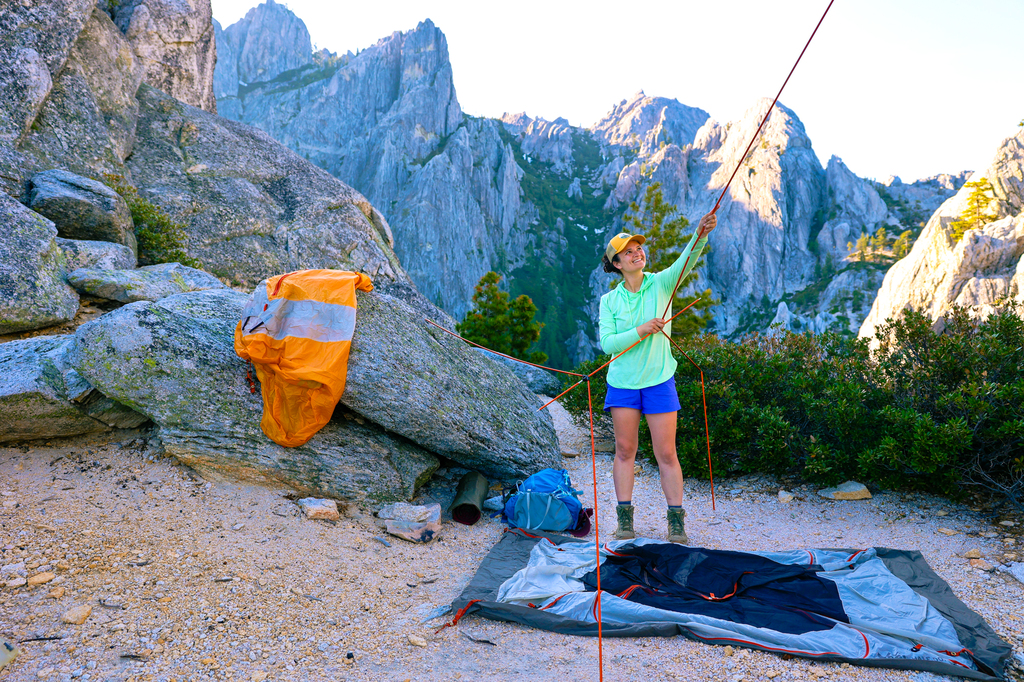 Woman setting up a backpacking tent at castle crags in california backpacking gear guide
